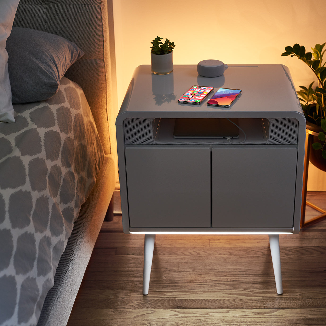 Close up of a dark sobro side table with white LED light lit up in front.